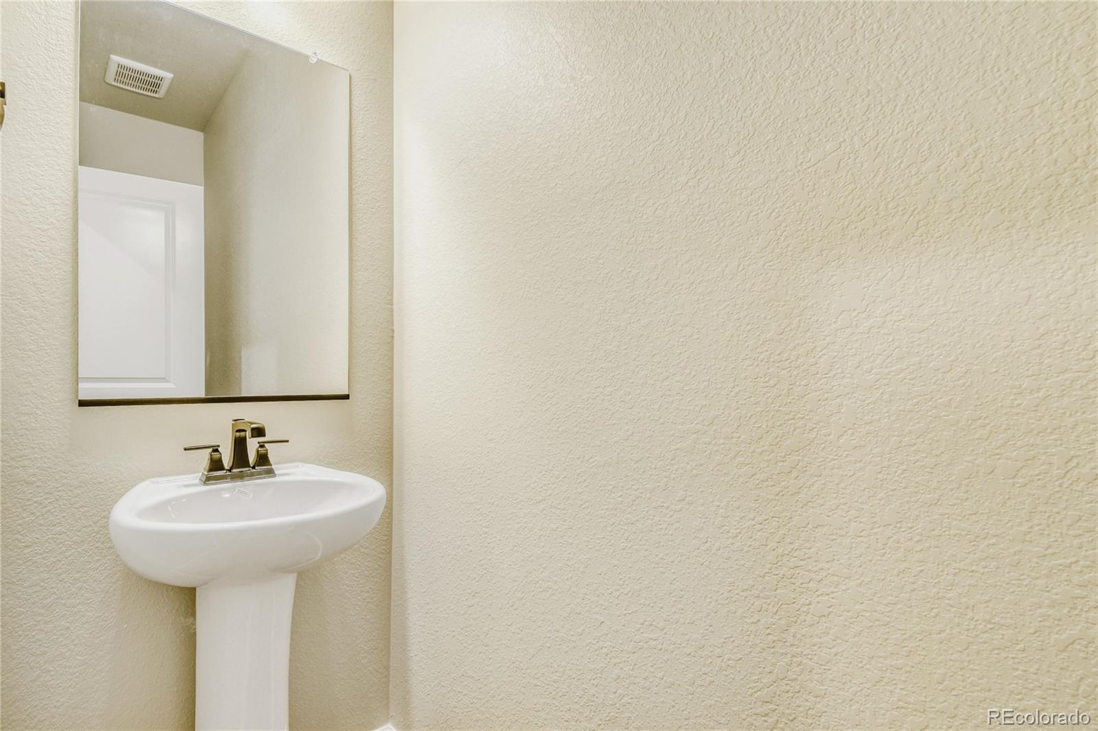 4135 Runyon Street Brighton, CO 80601 - Photo 26 of 27 a bathroom with a sink and a mirror