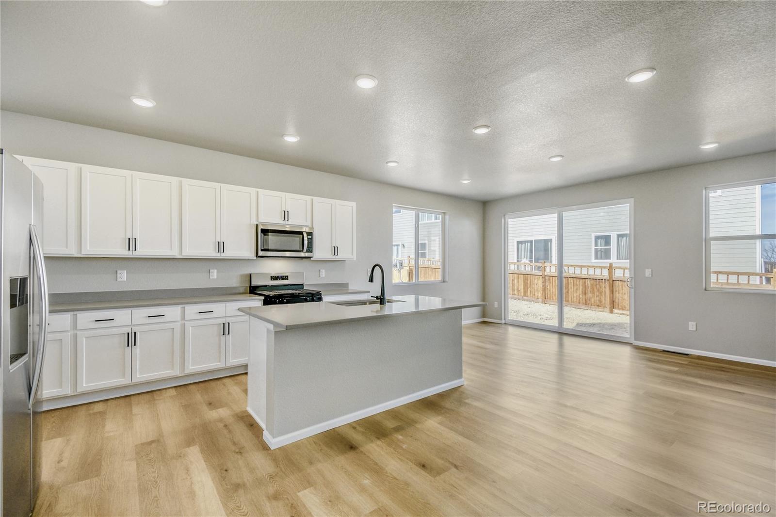4135 Runyon Street Brighton, CO 80601 - Photo 4 of 27 a large kitchen with cabinets