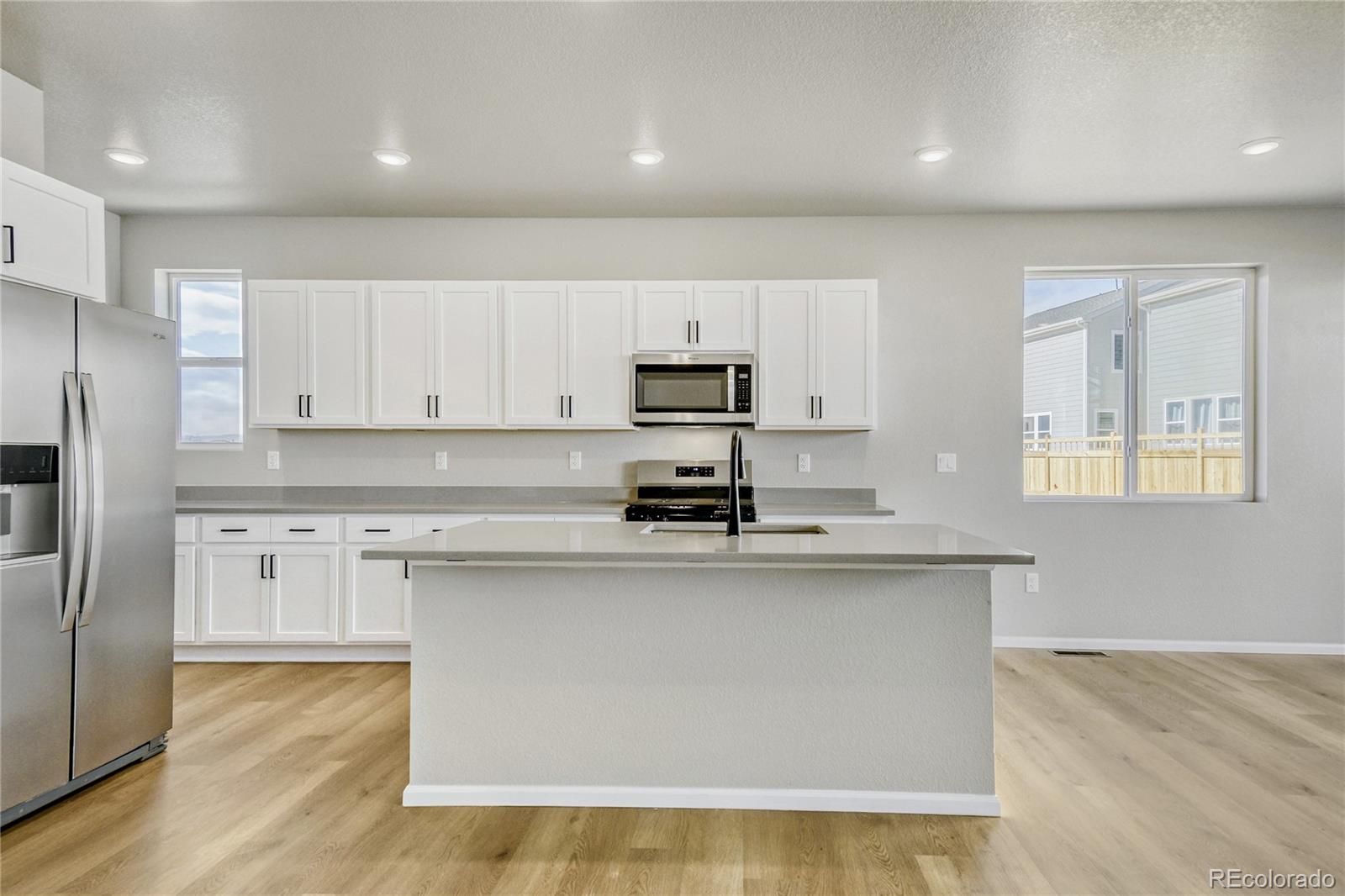 4135 Runyon Street Brighton, CO 80601 - Photo 5 of 27 a kitchen with stainless steel appliances granite countertop a stove a sink and a refrigerator