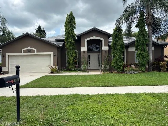 a front view of a house with a yard and garage