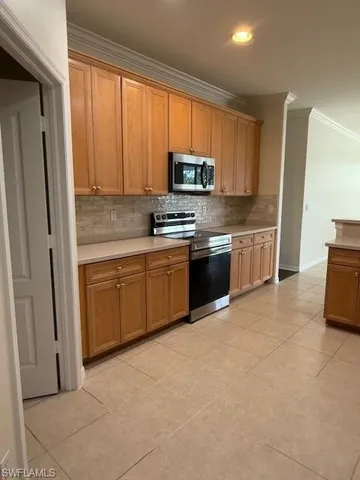 a kitchen with stainless steel appliances granite countertop a stove top oven a sink and a refrigerator