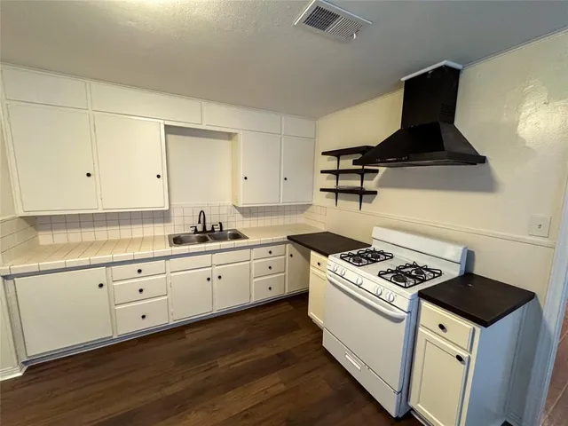 a kitchen with granite countertop white cabinets and white appliances