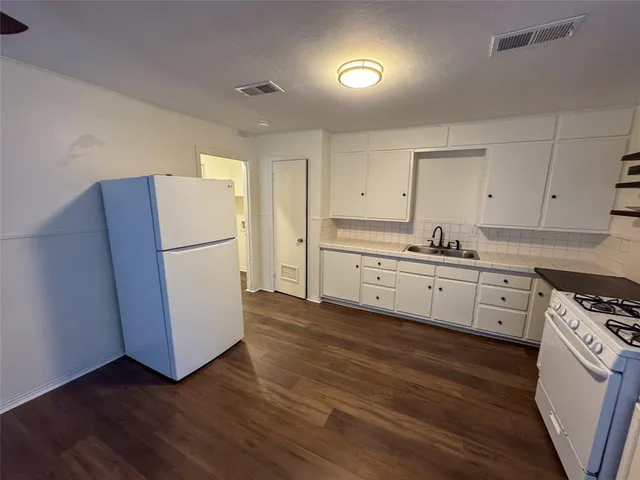 a kitchen with white cabinets and white appliances