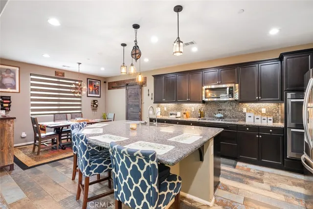 a kitchen with kitchen island a large counter top space appliances and cabinets