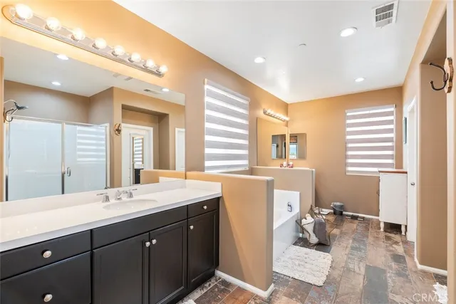 a bathroom with a sink mirror and a bathtub