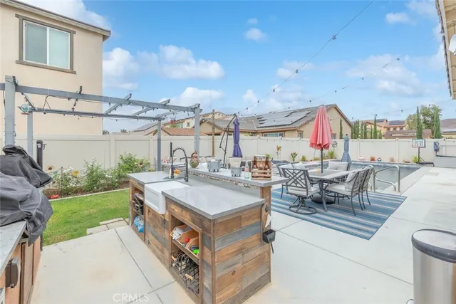 a view of a patio with dining table and chairs with a barbeque grill and plants