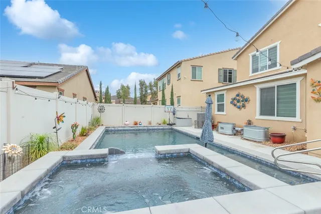 a view of a patio with couches and table and chairs with wooden fence