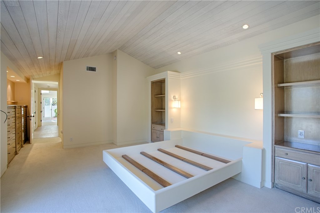 1 Seafaring Drive Corona del Mar, CA 92625 - Photo 22 of 25 a spacious bedroom with a bed and a large mirror