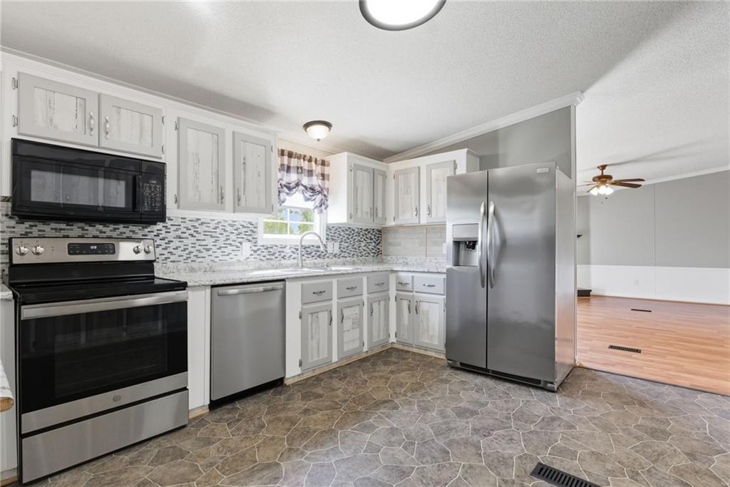 294 Old Ball Ground Road Canton, GA 30115 - Photo 19 of 40 a kitchen with stainless steel appliances granite countertop a refrigerator stove and microwave