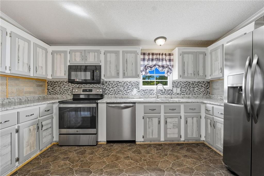 294 Old Ball Ground Road Canton, GA 30115 - Photo 20 of 40 a kitchen with stainless steel appliances granite countertop a stove a sink and a refrigerator