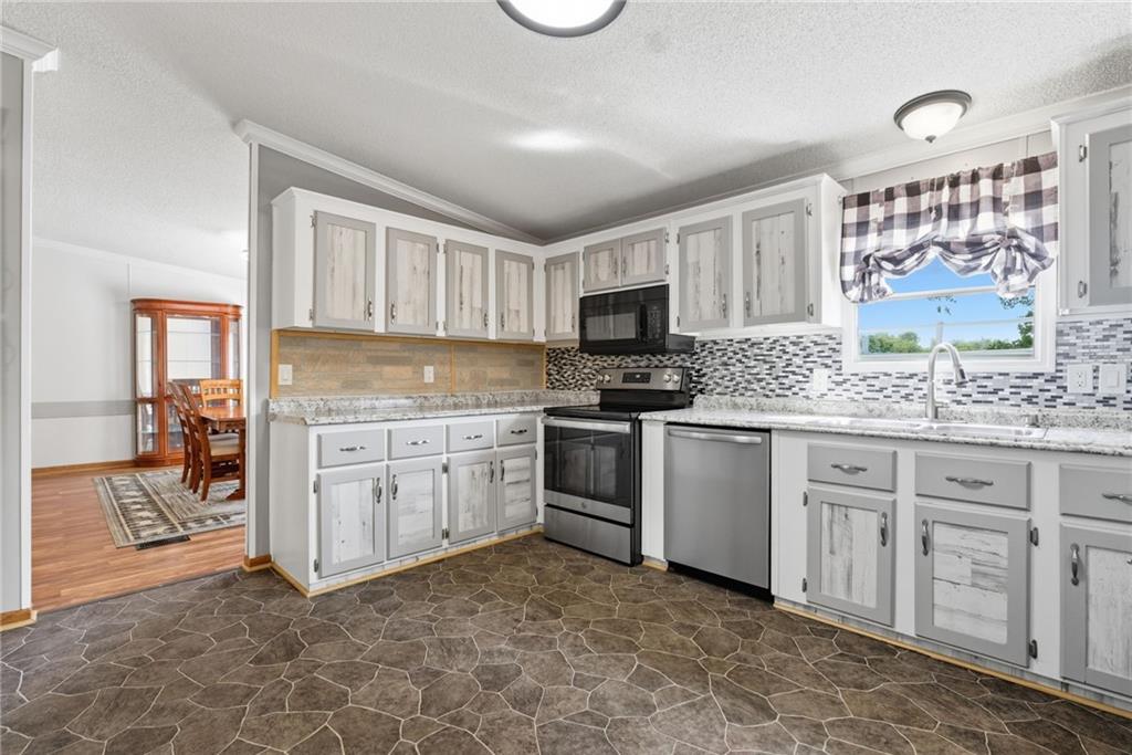 294 Old Ball Ground Road Canton, GA 30115 - Photo 21 of 40 a kitchen with white cabinets and appliances