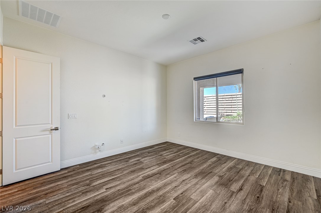 8197 Riley Love Street Las Vegas, NV 89139 - Photo 28 of 48 Well-lit room features resilient wood-look flooring and a functional window with a privacy blind.