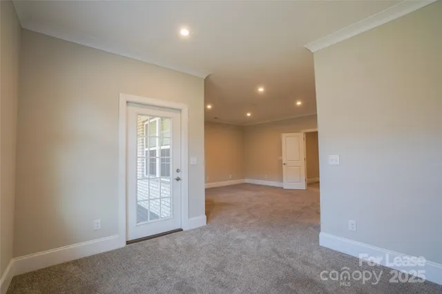 an empty room with windows and entrance to other room