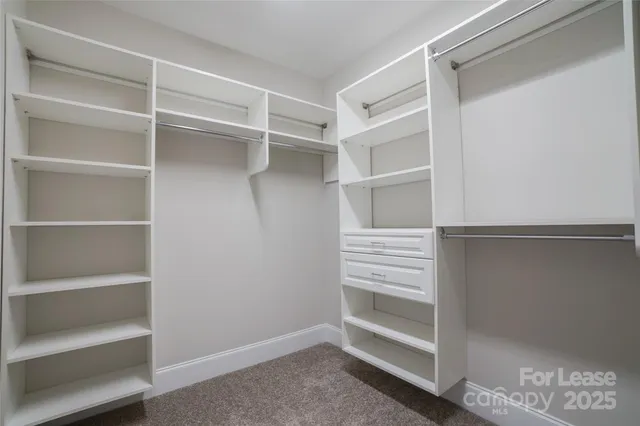 a view of walk in closet with empty racks