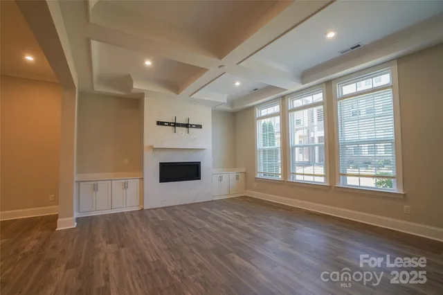 an empty room with wooden floor and fireplace