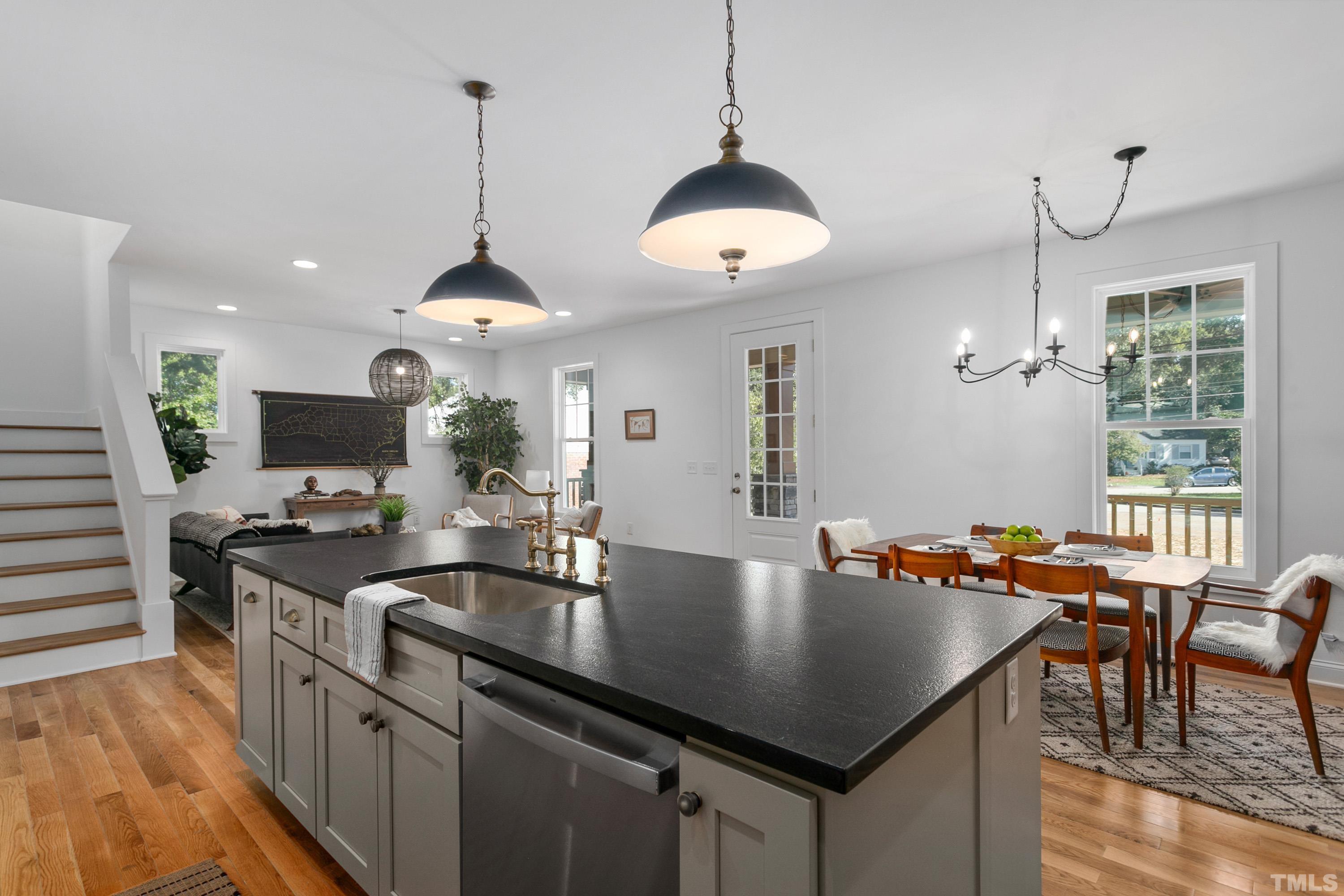 202 Myers Avenue Raleigh, NC 27604 - Photo 7 of 26 a kitchen with stainless steel appliances granite countertop a stove a sink a dining table and chairs with wooden floor