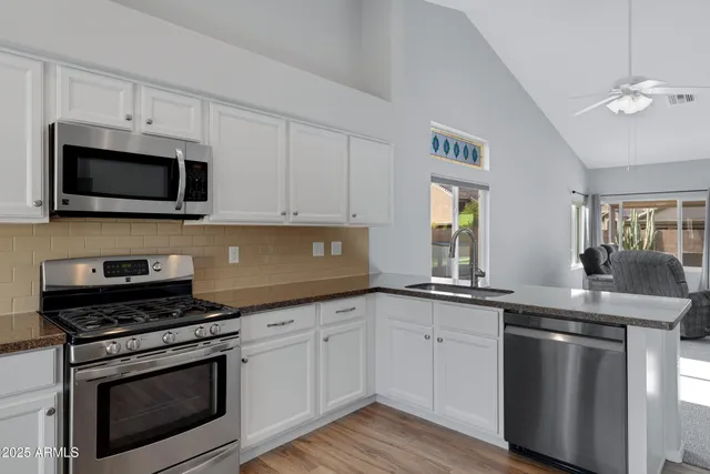 a kitchen with granite countertop a sink and steel appliances