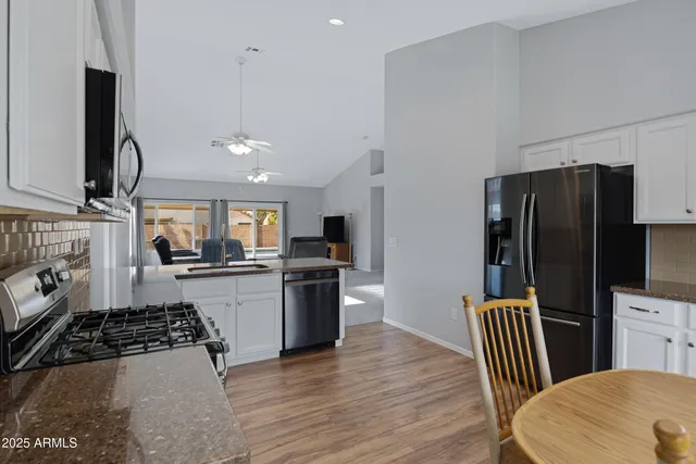 a kitchen with stainless steel appliances granite countertop a refrigerator stove top oven and sink