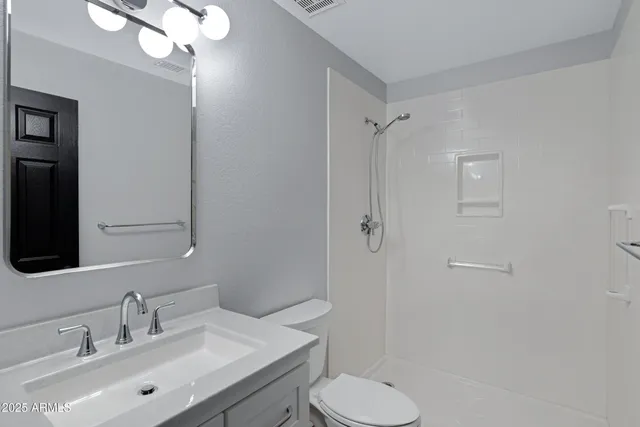 a bathroom with a sink toilet a mirror and shower