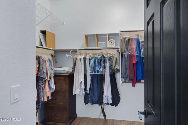 a view of walk in closet with clothes and shoes