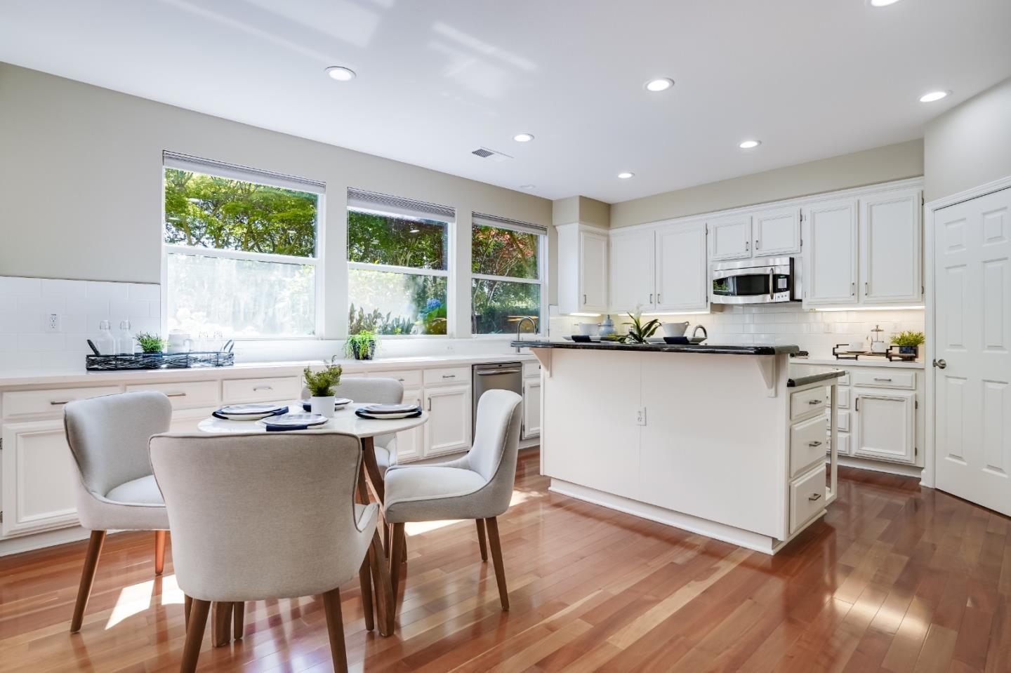 5929 Lantana Way San Ramon, CA 94582 - Photo 12 of 61 a kitchen with kitchen island granite countertop wooden floors and white stainless steel appliances