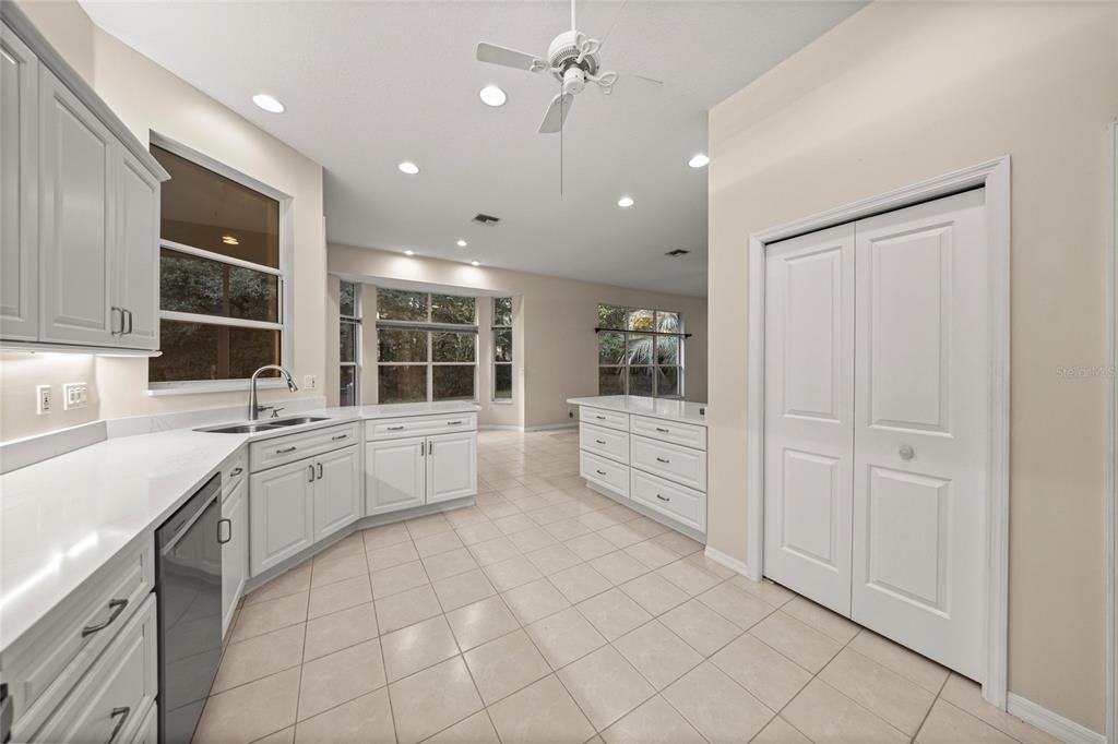 20698 Southwest 93rd Lane Road Dunnellon, FL 34431 - Photo 12 of 34 a large white kitchen with cabinets and chandelier