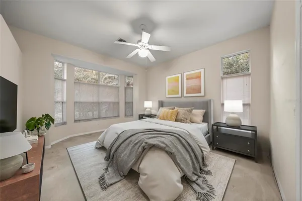 an empty room with chandelier fan and windows