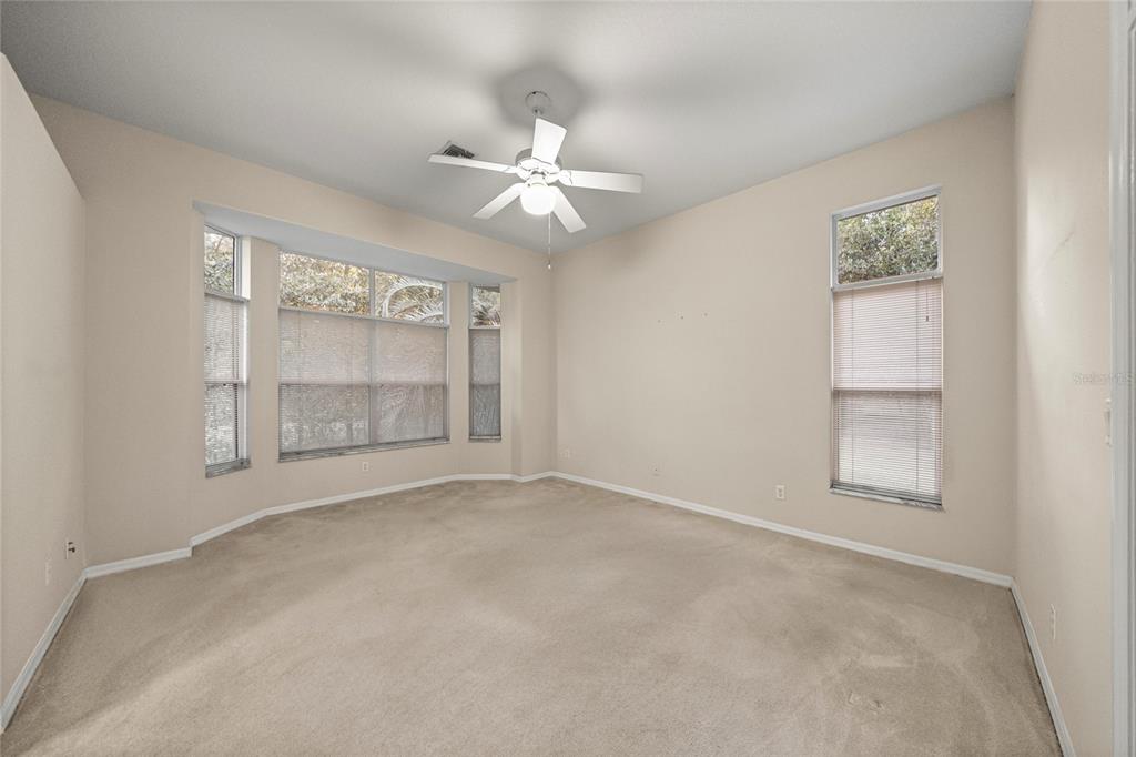 20698 Southwest 93rd Lane Road Dunnellon, FL 34431 - Photo 18 of 34 an empty room with chandelier fan and windows