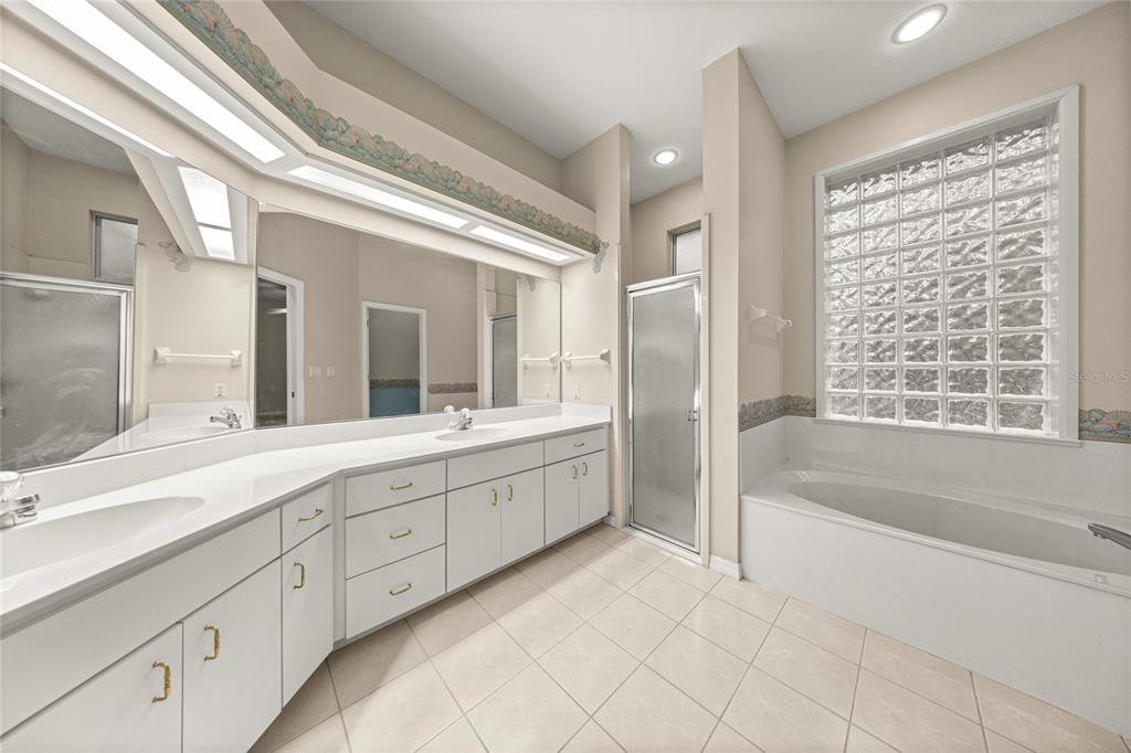 20698 Southwest 93rd Lane Road Dunnellon, FL 34431 - Photo 20 of 34 a spacious bathroom with a double vanity sink a mirror and a bathtub