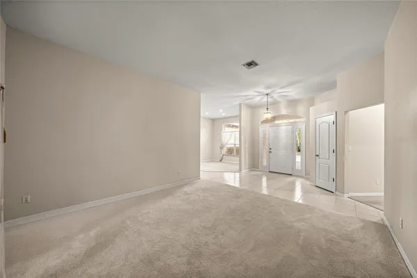 a large white kitchen with kitchen island a sink a counter top space and stainless steel appliances