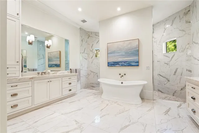 a bathroom with a double vanity sink mirror and bathtub