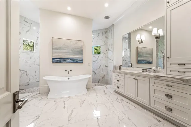 a bathroom with a double vanity sink mirror and bathtub