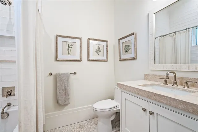 a bathroom with a granite countertop toilet sink and mirror