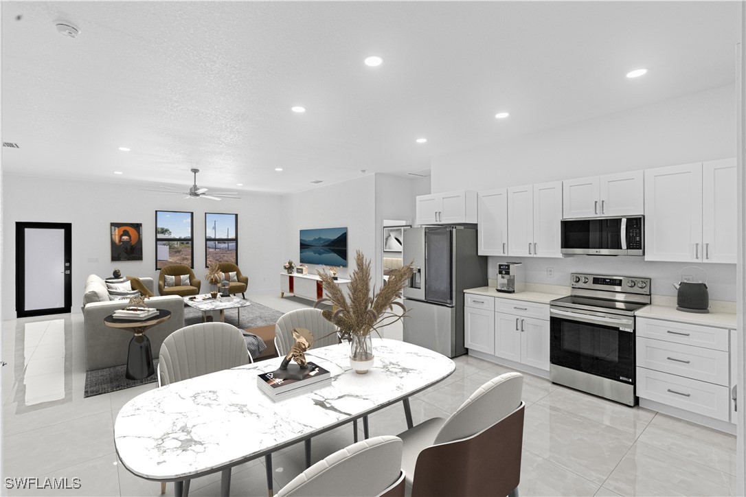 7029 Hero Court LaBelle, FL 33935 - Photo 12 of 36 a kitchen with stainless steel appliances kitchen island granite countertop a stove a sink a dining table and chairs