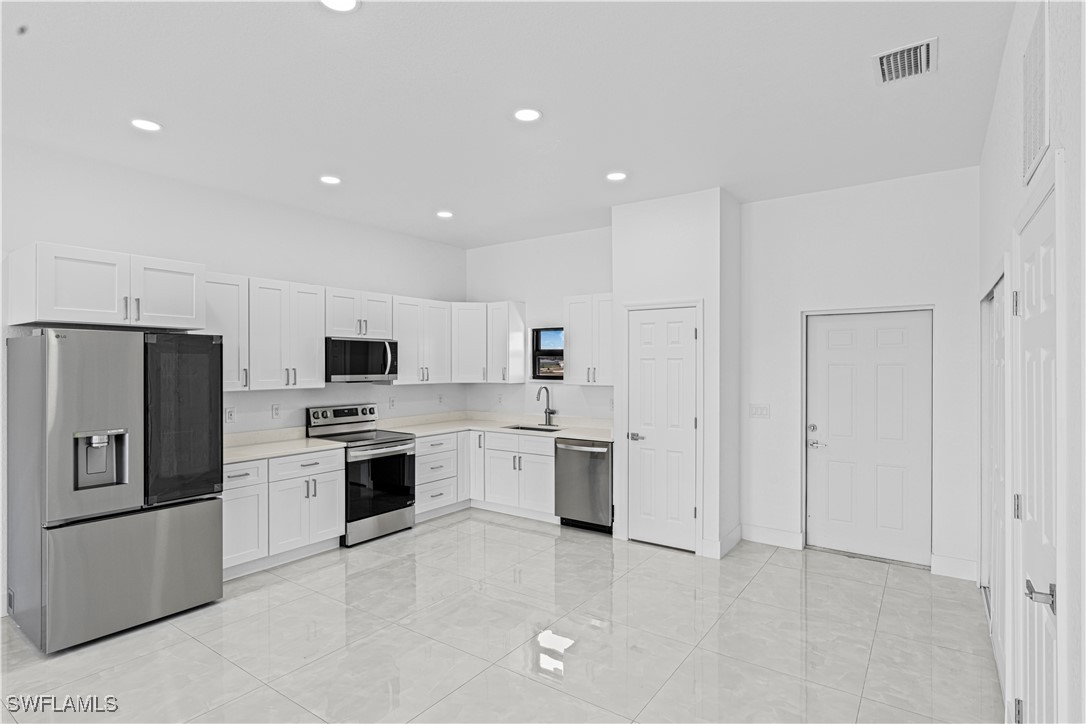 7029 Hero Court LaBelle, FL 33935 - Photo 15 of 36 a kitchen with stainless steel appliances a refrigerator stove microwave and sink