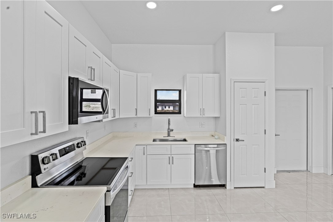 7029 Hero Court LaBelle, FL 33935 - Photo 17 of 36 a kitchen with white cabinets and appliances