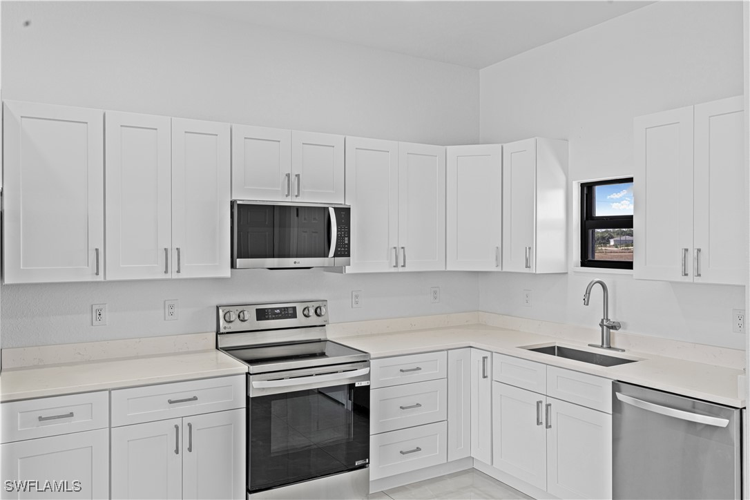 7029 Hero Court LaBelle, FL 33935 - Photo 18 of 36 a kitchen with white cabinets and stainless steel appliances