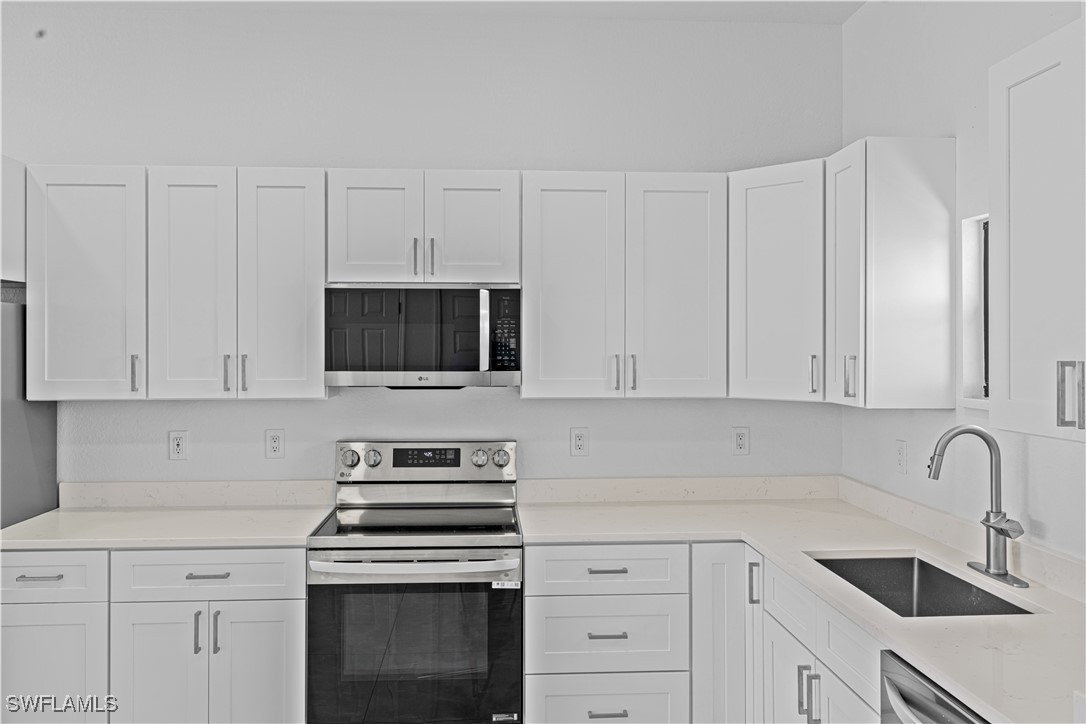 7029 Hero Court LaBelle, FL 33935 - Photo 19 of 36 a kitchen with white cabinets and stainless steel appliances