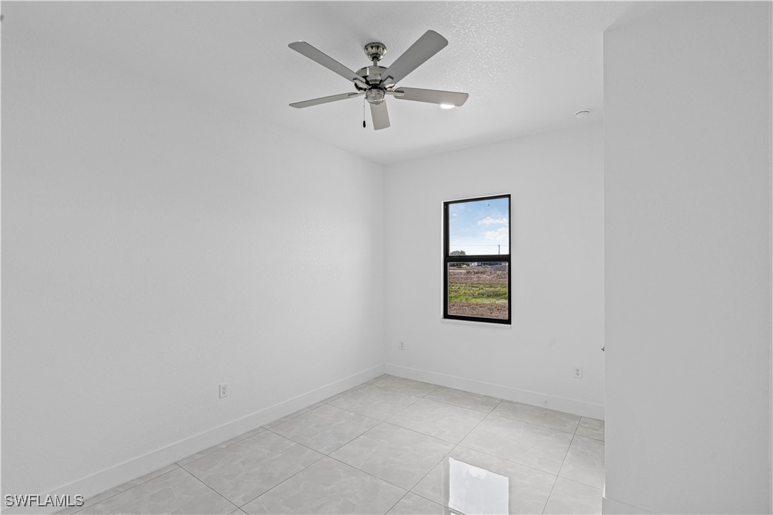 7029 Hero Court LaBelle, FL 33935 - Photo 22 of 36 an empty room with a window and a ceiling fan