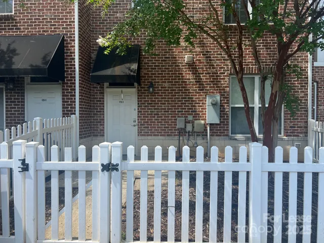 a front view of brick house with a fence