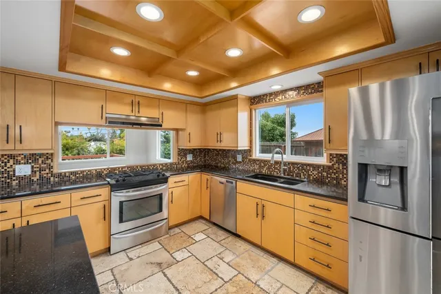 a kitchen with stainless steel appliances granite countertop a sink stove and refrigerator