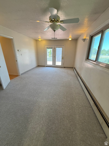 328 Heather Ridge Circle Sandy, UT 84070 - Photo 10 of 32 Carpeted room featuring a ceiling fan with light fixture, dual pane windows, and patio doors