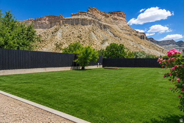 100 Third North Helper, UT 84526 - Photo 5 of 30 Expansive green lawn with a dark privacy fence and concrete border