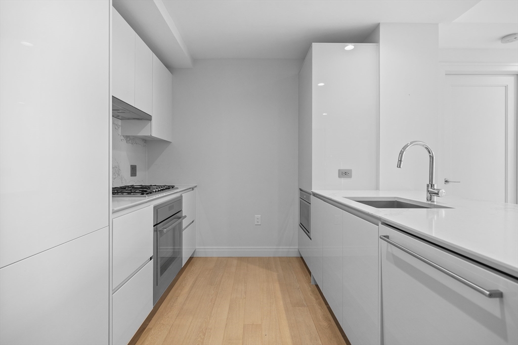 135 Seaport Boulevard, Unit 905 Boston, MA 02210 - Photo 9 of 21 a kitchen with a sink and a stove top oven