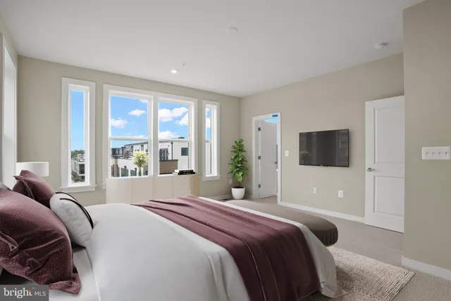 a bedroom with a bed and a large window