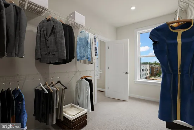 a view of walk in closet with clothes and shoes