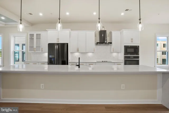 a large kitchen with stainless steel appliances kitchen island a large island a refrigerator and a sink