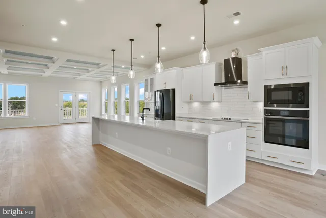 a kitchen with kitchen island a counter top space appliances and a ceiling fan