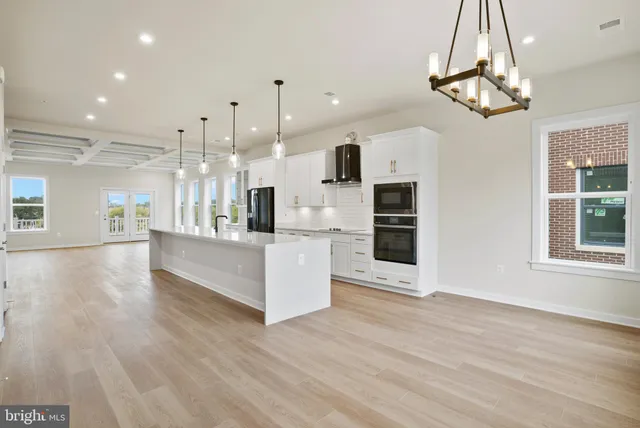 a view of a kitchen with kitchen island stainless steel appliances refrigerator stove microwave and cabinets