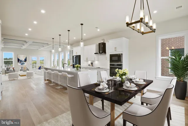 a view of a dining room and livingroom with furniture wooden floor a chandelier